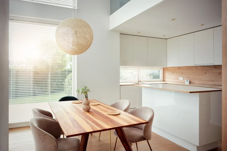 Jadalnia z drewnianym stołem przy aneksie kuchennym
