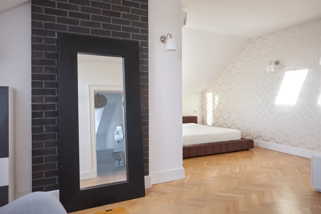 Sypialnia z łóżkiem i dekoracyjną ścianą z cegły