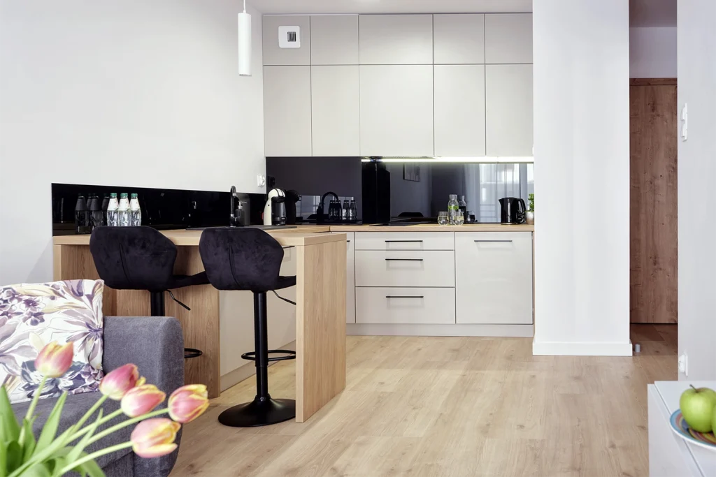 Kuchnia z jasną zabudową i czarnym blatem