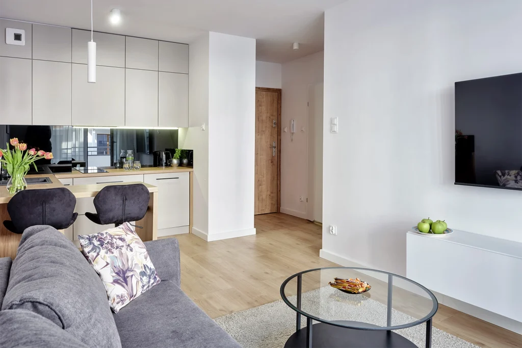 Salon z aneksem kuchennym i hokerami przy blacie