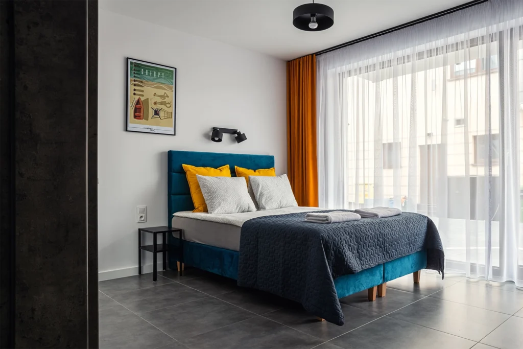 Sypialnia z łóżkiem i kolorowymi poduszkami