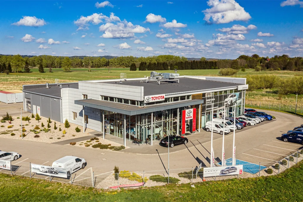 Budynek usługowy z parkingiem i otoczeniem – fotografia architektury