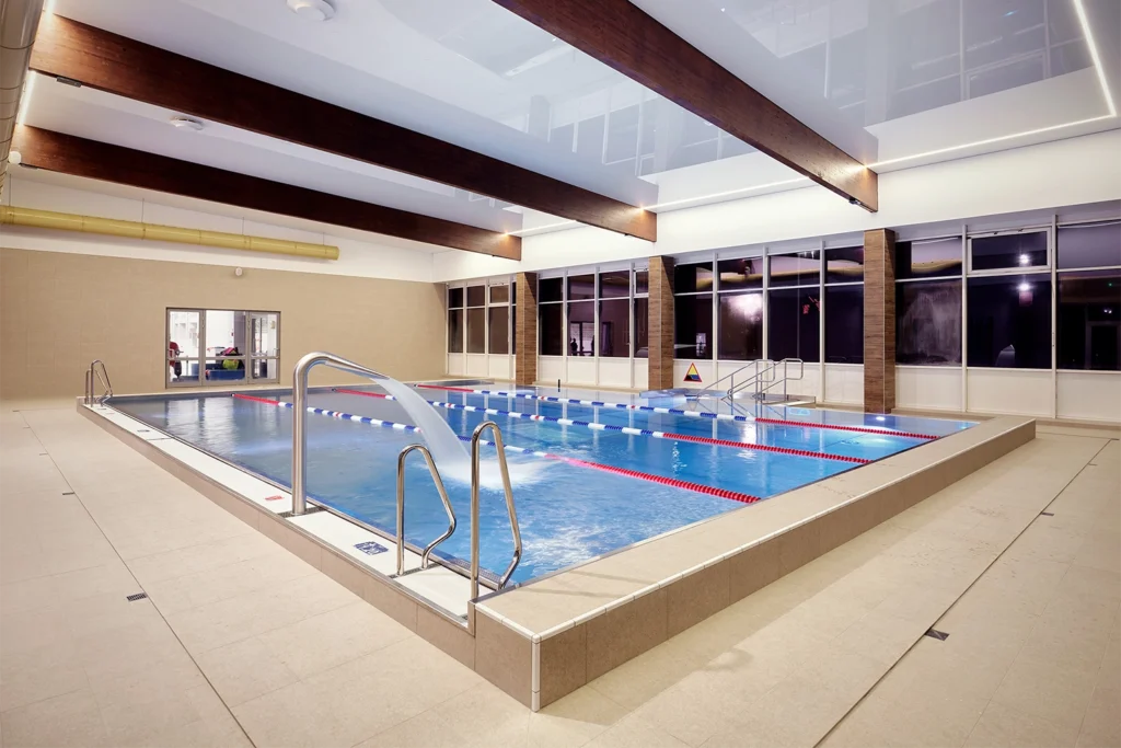 Strefa basenowa z dużymi oknami i drewnianymi belkami