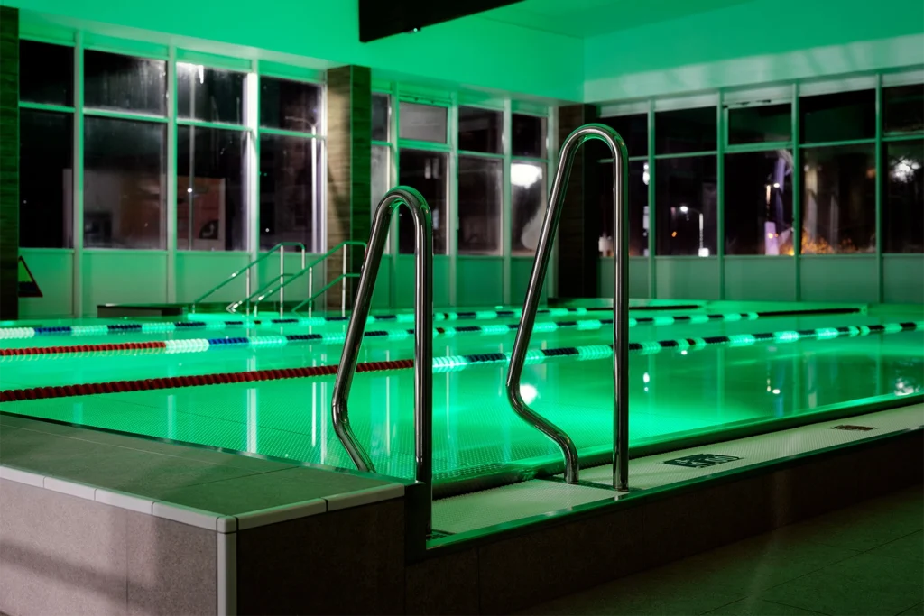 Basen z zielonym podświetleniem i wejściem po schodkach