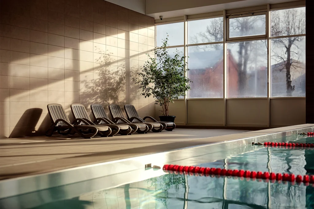 Strefa relaksu przy basenie z dużymi przeszkleniami