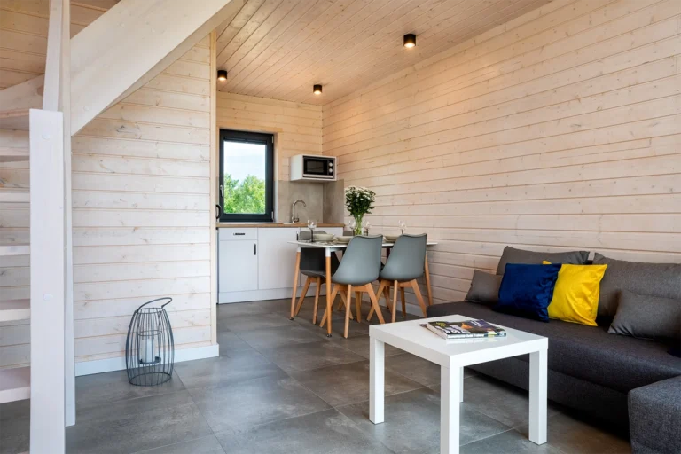 Salon z aneksem kuchennym w jasnym, drewnianym wnętrzu