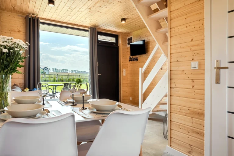 Jadalnia przy dużym oknie w drewnianym wnętrzu